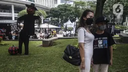 Pengunjung berfoto dengan karakter labu saat Parade Kostum Halloween di Mall Central Park, Jakarta, Sabtu (30/10/2021). Parade Kostum Halloween kali ini akan dipenuhi dekorasi dan instalasi bertemakan berbagai ornamen layaknya seperti di negeri ajaib. (Liputan6.com/Johan Tallo)