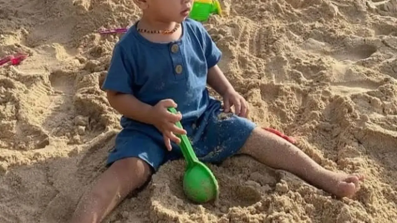 Gala Sky Andriansyah bermain pasir tanpa alas kaki.