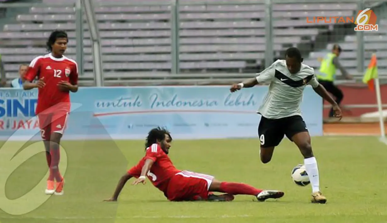 Sesekali pemain tengah Papua Nugini Dabinyaba Nigel (9) mencoba menembus sisi kanan pertahana Maladewa (Liputan6.com/Helmi Fithriansyah)