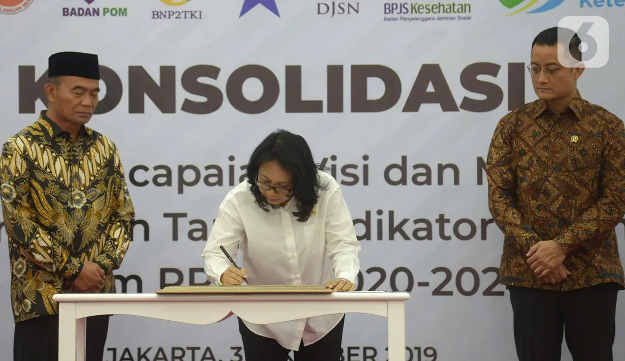 Menteri PPPA Gusti Ayu Bintang (tengah) menandatangani berkas disaksikan Menko PMK Muhadjir Effendy (kiri) dan Mensos Jualiari Batubara (kanan) saat rapat koordinasi di Gedung Kemenko PMK, Jakarta, Kamis (31/10/2019). (merdeka.com/Imam Buhori)