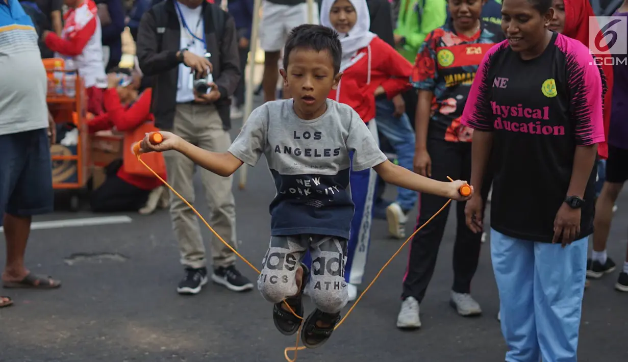Seorang anak mencoba olahraga lompat tali atau jumping rope bersama komunitas penggerak olahraga di tengah kegiatan Car Free Day kawasan Bundaran Hotel Indonesia, Minggu (30/6/2019). Kegiatan tersebut mengajak masyarakat untuk hidup sehat dengan berolahraga. (Liputan6.com/Immanuel Antonius)