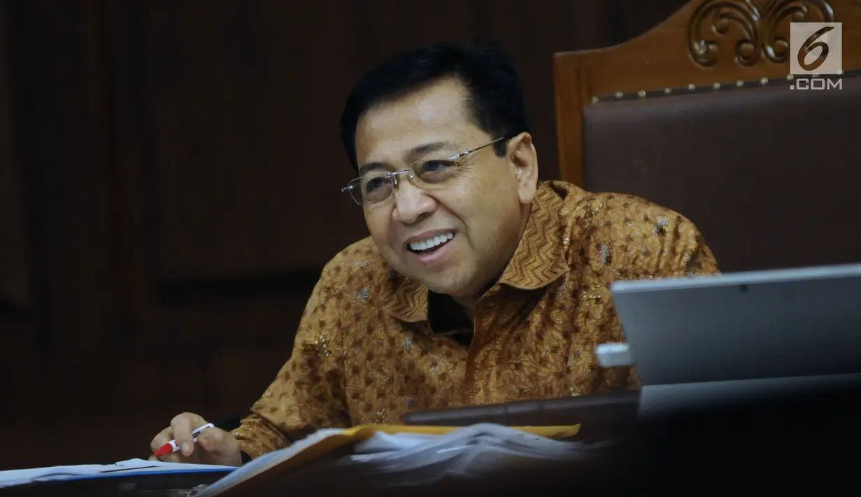 Terdakwa dugaan korupsi proyek e-KTP, Setya Novanto tersenyum saat menyimak keterangan saksi Charles Sutanto Ekapradja pada sidang lanjutan di Pengadilan Tipikor, Jakarta, Senin (22/1). Sidang menghadirkan sejumlah saksi. (Liputan6.com/Helmi Fithriansyah)