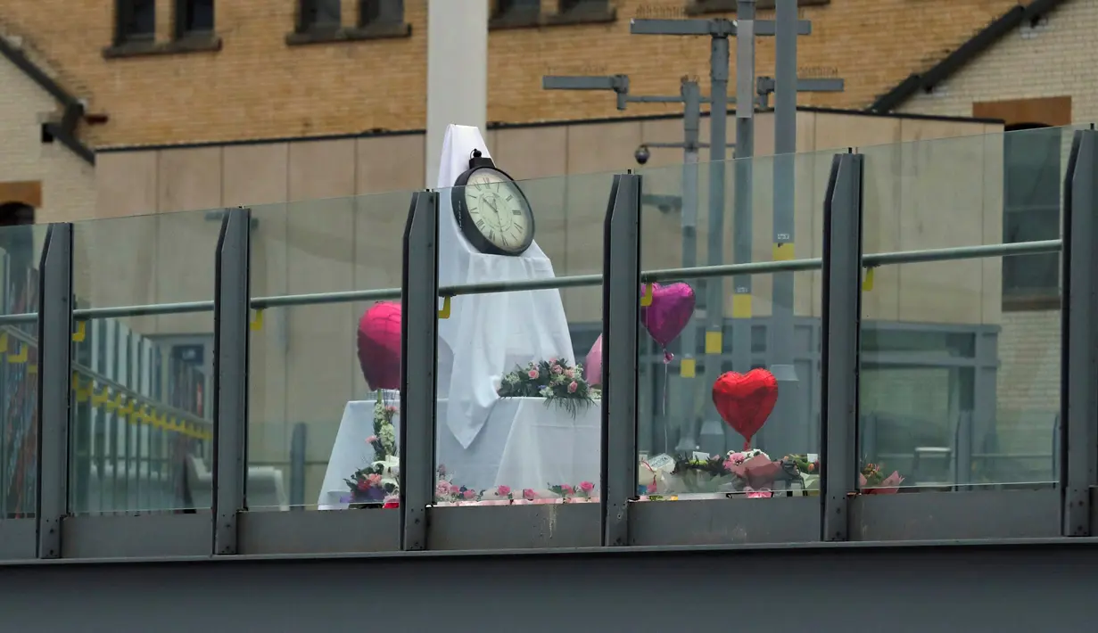 Bunga dan balon diletakkan dekat jalan setapak yang menghubungkan stasiun kereta Manchester Victoria dan Manchester Arena, Inggris, (30/5). Stasiun itu kembali dibuka setelah sepekan lebih insiden pengeboman di Manchester Arena. (Owen Humphreys/PA via AP)