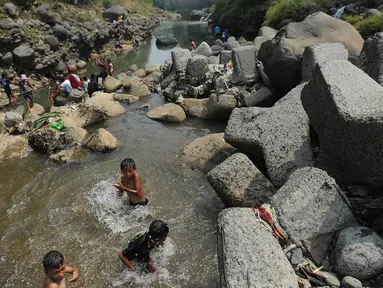 Anak-anak bermain pada kubangan air yang tersisa di kawasan Bendungan Katulampa, Bogor (15/7). Musim kemarau menyebabkan Bendungan Katulampa berada di titik nol berdampak pada sumur-sumur warga di sekitar mengalami kekeringan. (Merdeka.com/Arie Basuki)