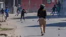 Para pemuda Kashmir melempari batu ke arah tentara paramiliter India di Srinagar, Kashmir, India, (1/4). Pengunjuk rasa memprotes menyusul tewasnya delapan pemberontak dalam bentrokan dengan pasukan pemerintah. (AP Photo / Dar Yasin)