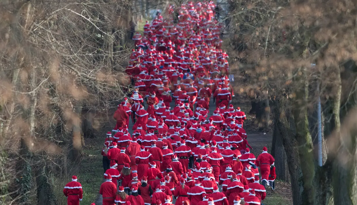 Para peserta mengenakan kostum Santa Claus berpartisipasi dalam Santa Claus Run di Michendorf, Jerman timur, Minggu (10/12). Kegiatan amal yang digelar setiap tahun ini diikuti ribuan warga Jerman dan wisatawan mancanegara. (Ralf Hirschberger/dpa via AP)