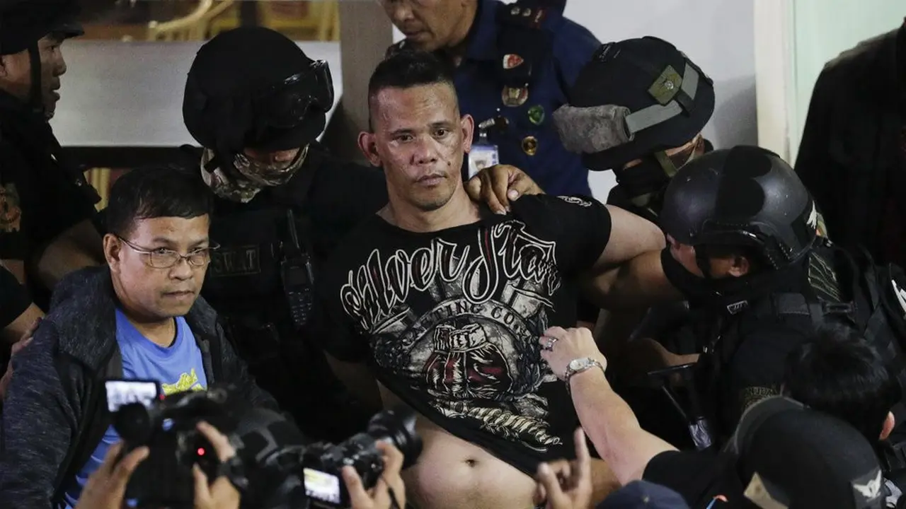 Polisi menahan penyandera Alchie Paray saat ia berbicara kepada media tak lama setelah melepaskan semua sandera di V-Mall di Manila, Filipina pada hari Senin, 2 Maret 2020.