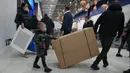 Orang-orang membawa pembelian mereka saat toko IKEA tutup di pinggiran St. Petersburg, Kamis (3/3/2022). Peritel IKEA menghentikan operasional di "Negeri Beruang Merah" dan Belarusia untuk sementara waktu mulai Jumat, 4 Maret 2022 buntut dari invasi Rusia ke Ukraina. (AP Photo/Dmitri Lovetsky)