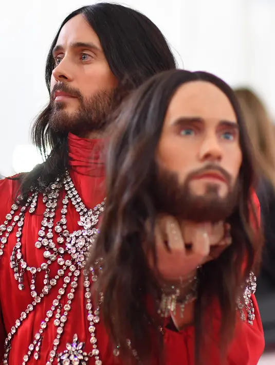 Jared Leto memegang replika potongan kepalanya sendiri saat menghadiri pergelaran Met Gala di Metropolitan Museum of Art New York, AS, Senin (6/5/2019). Leto memamerkan replika kepala yang sangat menyerupai wajahnya, lengkap dengan kumis dan jenggot. (ANGELA  WEISS / AFP)