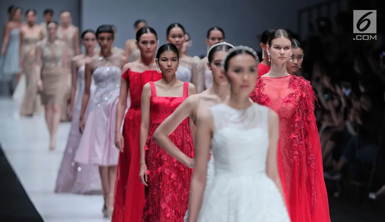 Sejumlah model berjalan diatas catwalk membawakan rancangan desainer Cherryn Lim di Jakarta Fashion Week 2018 di Senayan City, Jakarta, Kamis (26/10). Cherryn Lim mempersembahkan 25 koleksi gaun malam dan 5 gaun pengantin. (Liputan6.com/Faizal Fanani)