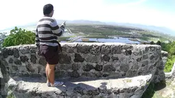Seorang wisatawan mengunjungi Benteng Otanaha di Kota Gorontalo, 5 Juli 2016. Benteng yang dibangun sekitar tahun 1522 ini terletak di atas sebuah bukit dan memiliki 348 buah anak tangga ke puncak sampai ke lokasi benteng. (Liputan6.com/Herman Zakharia)