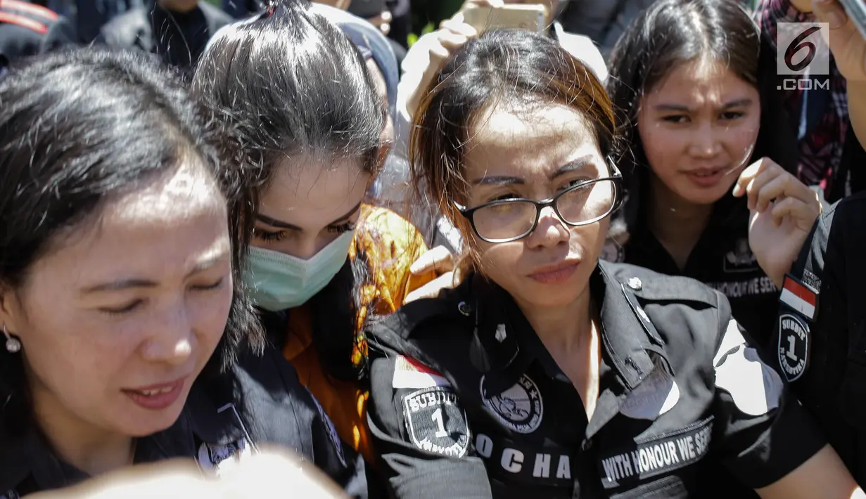 Artis sekaligus tersangka kasus narkoba Jennfer Dunn dikawal ketat penyidik Polda Metro Jaya setibanya di Kejaksaan Negeri Jakarta Selatan, Kamis (15/3). Jennfer Dunn terus menunduk tanpa mengucapkan sepatah kata pun. (Liputan6.com/Faizal Fanani)