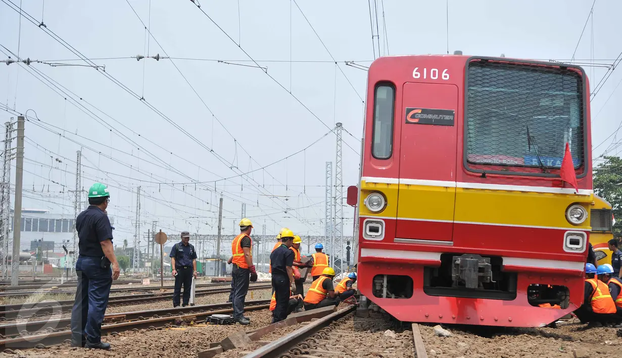 Petugas mengevakuasi gerbong kereta yang anjlok di jalur kereta api manggarai, Jakarta, Selasa (27/10/2015). Para penumpang dipindahkan dan duit tiket dikembalikan di stasiun terdekat. (Liputan6.com/Gempur M Surya)