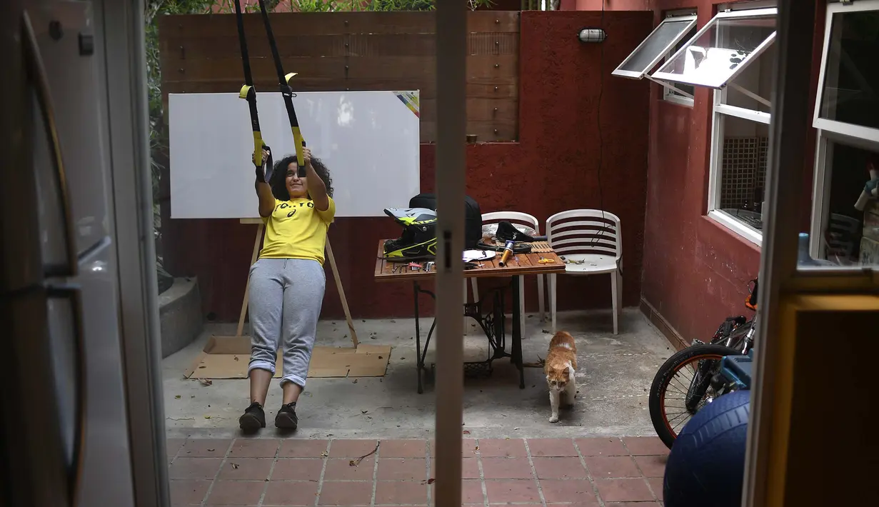 Atlet BMX asal Venezuela, Stefany Hernandez melakukan peregangan di rumahnya di Caracas, 25 April 2020. Di tengah karantina wilayah guna mengekang penyebaran Covid-19, peraih medali Olimpiade 2016 itu berlatih tiga kali seminggu untuk meraih tiket tampil di Olimpiade 2021. (AP/Matias Delacroix)