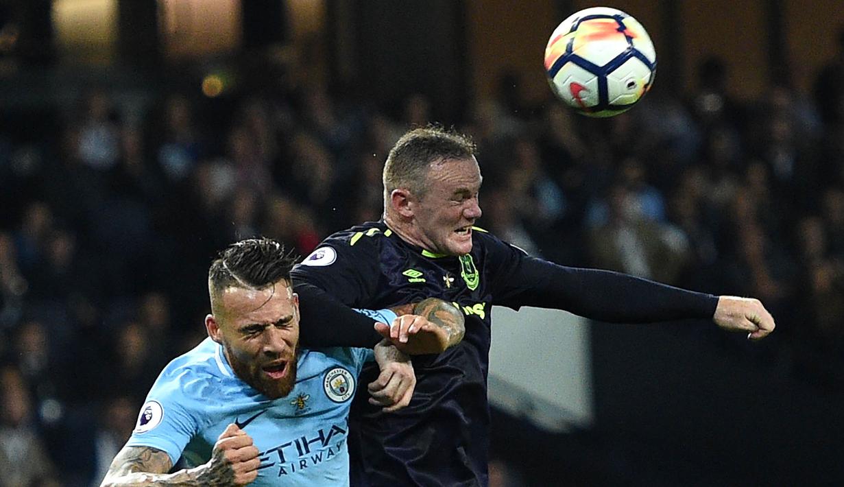 Striker Everton, Wayne Rooney, duel udara dengan bek Manchester City, Nicolas Otamendi, pada laga Premier League di Stadion Etihad, Selasa (22/8/2017). Wayne Rooney berhasil mencetak gol ke 200 di ajang Premier League. (AFP/Oli Scarff)