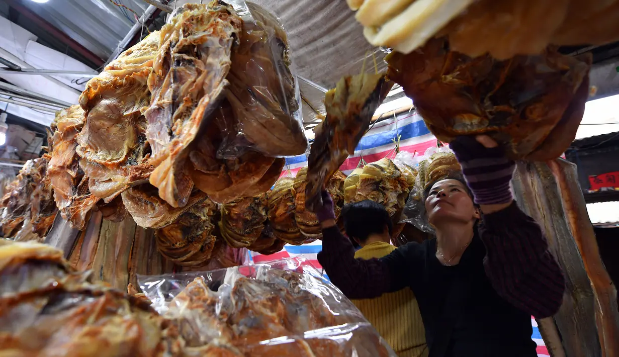 Penjual menata makanan laut kering di sebuah pasar di Kota Haikou, Provinsi Hainan, China, Rabu (15/1/2020). Warga Haikou akhir-akhir ini sibuk berbelanja untuk menyambut Tahun Baru Imlek 2020. (Xinhua/Guo Cheng)