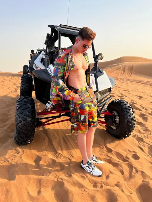 Dengan latar belakang foto berupa gurun pasir, Varrel tampil dengan busana berwarna-warni  dan memamerkan otot perutnya yang sixpack.  (Instagram/bramastavrl)