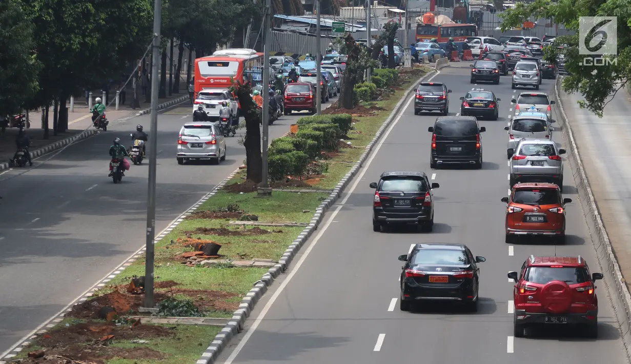 Kendaraan melintas di samping-pohon-pohon yang telah ditebang di Jalan Sudirman, Jakarta, Jumat (9/3). Sebanyak 541 pohon di sepanjang Jalan Sudirman-Thamrin ditebang imbas penataan trotoar yang akan dimulai Pemprov DKI. (Liputan6.com/Arya Manggala)