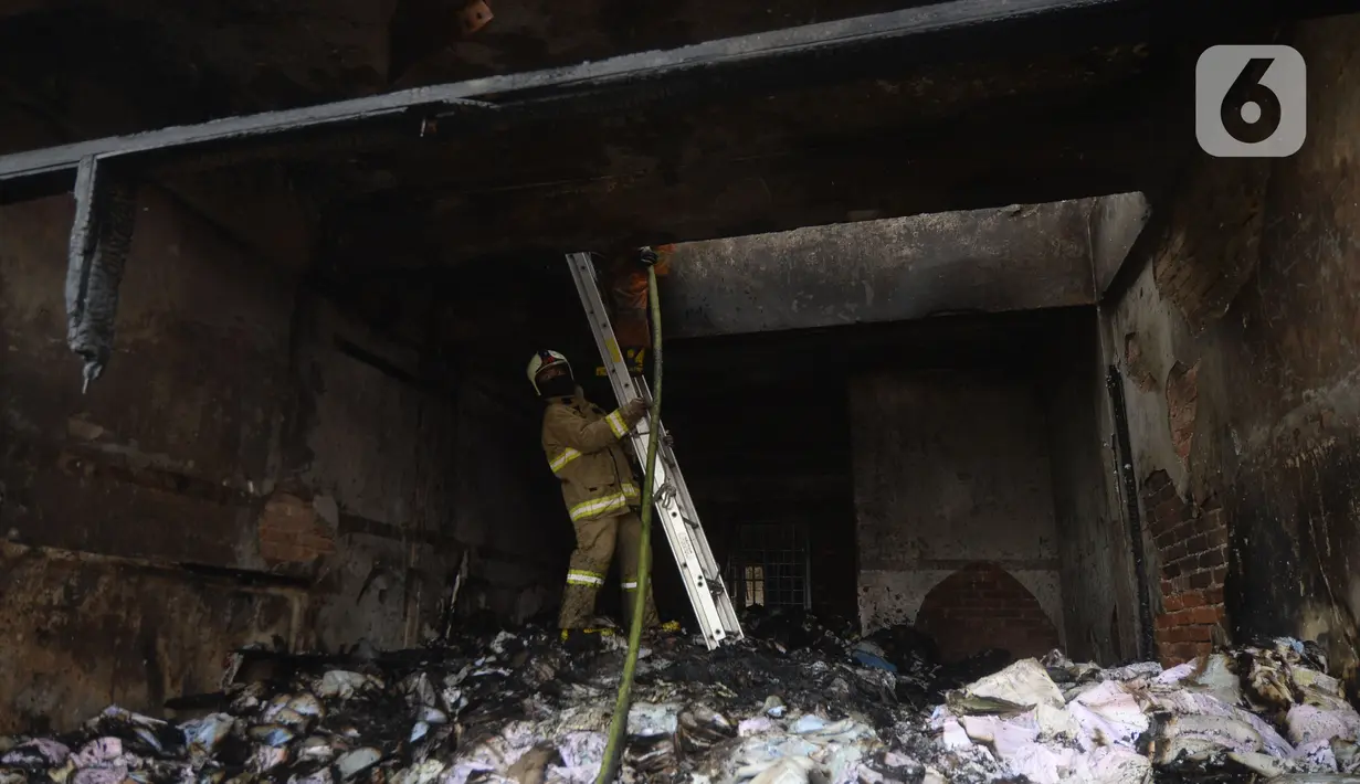 Petugas pemadam kebakaran melakukan pembasahan bioskop Grand Theater yang terbakar di Simpang Lima Senen, Jakarta, Jumat (9/10/2020). Unjuk rasa menentang disahkannya Omnibus Law UU Cipta Kerja berujung aksi anarkis merusak berbagai fasilitas umum pada Kamis malam (8/10). (merdeka.com/Dwi Narwoko)