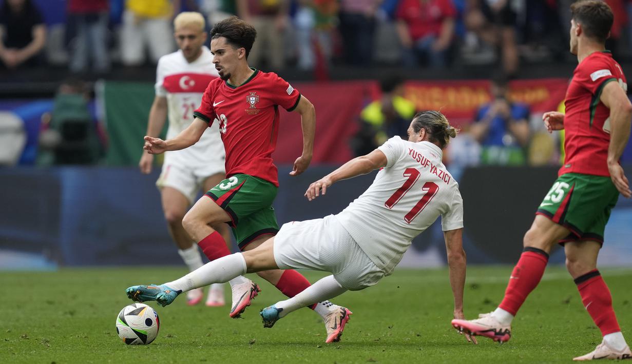 <p>Striker Timnas Turki, Yusuf Yazici (tengah) berusaha merebut bola dari penguasaan gelandang Timnas Portugal, Vitinha pada laga matchday kedua Grup F Euro 2024 Westfalenstadion, Dortmund, Jerman, Sabtu (22/6/2024). (AP Photo/Darko Vojinovic)</p>