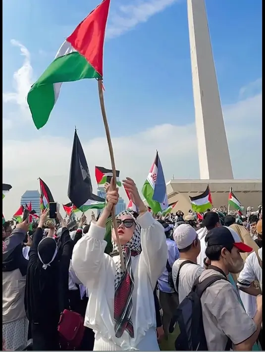 Desainer yang juga pengusaha Dian Pelangi ikut dalam aksi tersebut. Perempuan kelahiran Palembang itu hadir dengan outfit putih dan hijab motif hitam putih. Mengibarkan bendera Palestina. [Instagram/dianpelangi]
