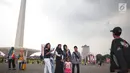 Sejumlah pengunjung berswafoto saat mengunjungi Monumen Nasional (Monas), Jakarta, Sabtu (22/12). Libur sekolah yang berbarengan dengan libur Natal dan Tahun Baru dimanfaatkan masyarakat untuk pergi berwisata ke Monas. (Liputan6.com/Faizal Fanani)
