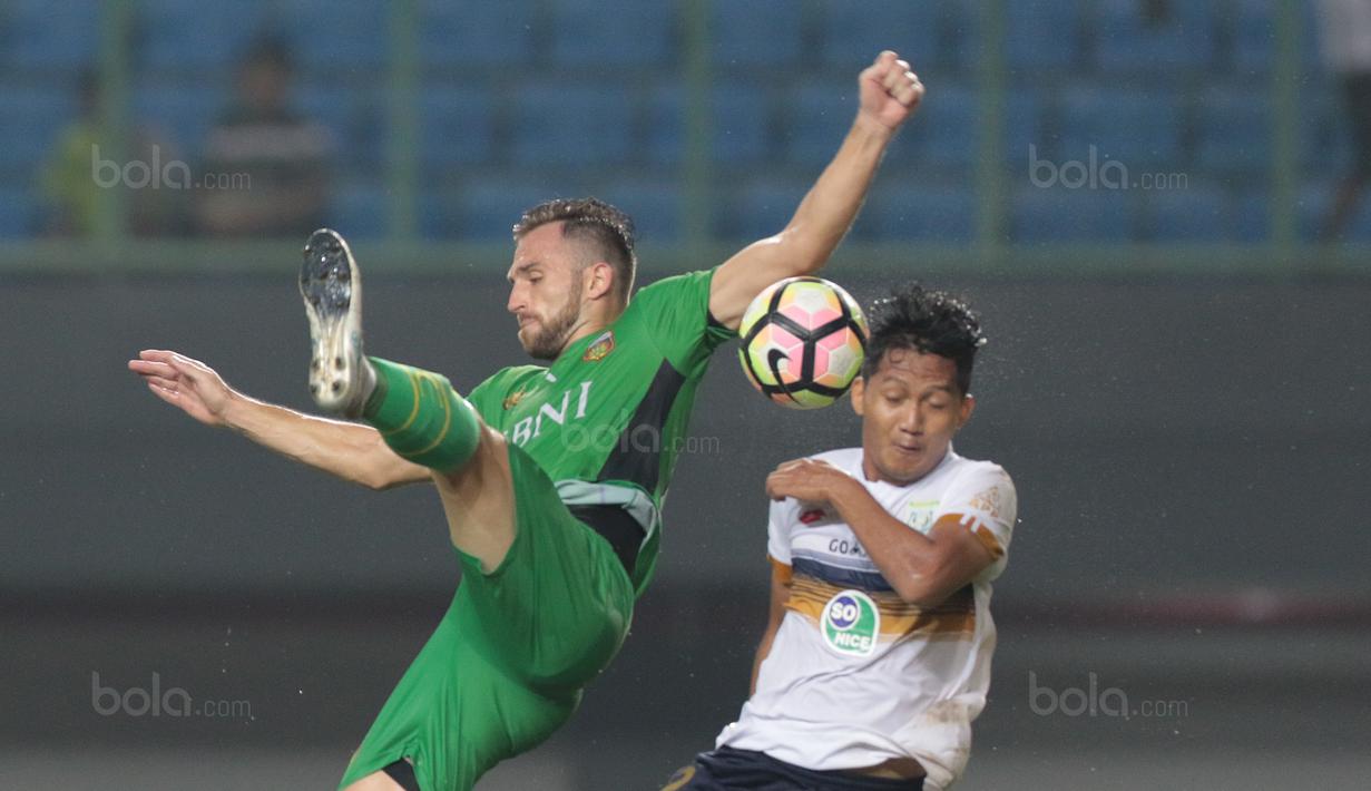 Duel pemain Bhayangkara FC, Ilija Spasojevic (kiri) dan pemain Persela Lamongan, Zainal Haq pada lanjutan Liga 1 2017 di Stadion Patriot, Bekasi, (27/10/2017). Bhayangkara menang 3-1. (Bola.com/Nicklas Hanoatubun)
