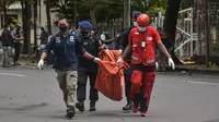 Polisi membawa tas berisi sisa-sisa tubuh tersangka pelaku bom bunuh diri setelah ledakan di luar sebuah gereja di Makassar (28/3/2021). Ledakan terjadi di Gerbang Gereja Katedral Makassar pada Minggu (28/3/2021). (AFP/Indra Abriyanto)