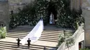 Meghan Markle tiba untuk melangsungkan pernikahannya dengan Pangeran Harry di St George's Chapel, Kastil Windsor, Windsor, Inggris, Sabtu (19/5). Meghan mengenakan gaun putih panjang di hari pernikahannya. (Andrew Matthews/POOL/AFP)