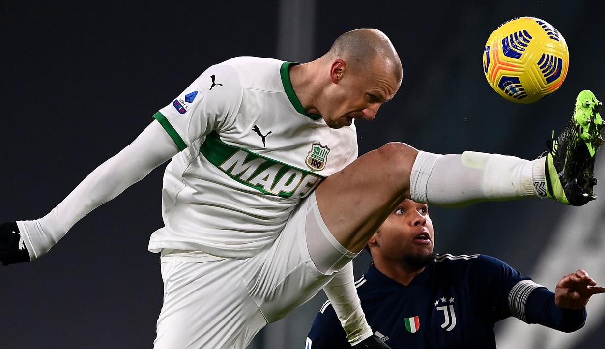 Bek Sassuolo, Vlad Chiriches (depan) berduel udara dengan gelandang Juventus, Weston McKennie dalam laga lanjutan Liga Italia Serie A 2020/21 pekan ke-17 di Juventus Stadium, Minggu (10/1/2021). Sassuolo kalah 1-3 dari Juventus. (AFP/Marco Bertorello)