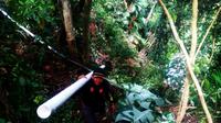 Bripka Musrudi mendaki gunung dan menerobos hutan demi memenuhi kebutuhan air warga Desa Tonasa, Kabupaten Gowa, Sulsel. (Liputan6.com/Eka Hakim)