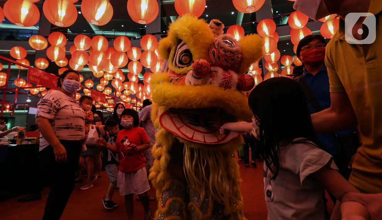 Pengunjung memberi angpao pada Barongsai yang beraksi di mal kawasan Jakarta, Minggu (30/1/2022). Dalam rangka menyambut Tahun Baru Imlek, Mal di Jakarta menghadirkan atraksi barongsai yang untuk menghibur pengunjung dan menarik daya beli masyarakat. (Liputan6.com/Johan Tallo)