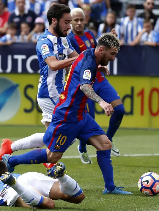Lionel Messi saat mengecoh dan melewati para pemain Leganes pada lanjutan La Liga Spanyol di Butarque stadium, Madrid, (17/09/2016). (EPA/Juan Carlos Hidalgo)