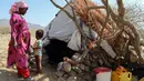 Seorang anak bersama ibunya berada di depan gubuk mereka di kamp pengungsian Taez, Yaman (11/1). Jutaan warga melarikan diri hingga ke wilayah dataran tinggi seperti Taez. (AFP Photo/Ahmad Al-Basha)