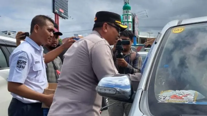 Wakapolresta Banyuwangi AKBP  Dewa Putu Eka Darmawan, bersama pihak ASDP Ketapang membagikan air mineral kepada para penumpang di dalam kendaraan (Istimewa)