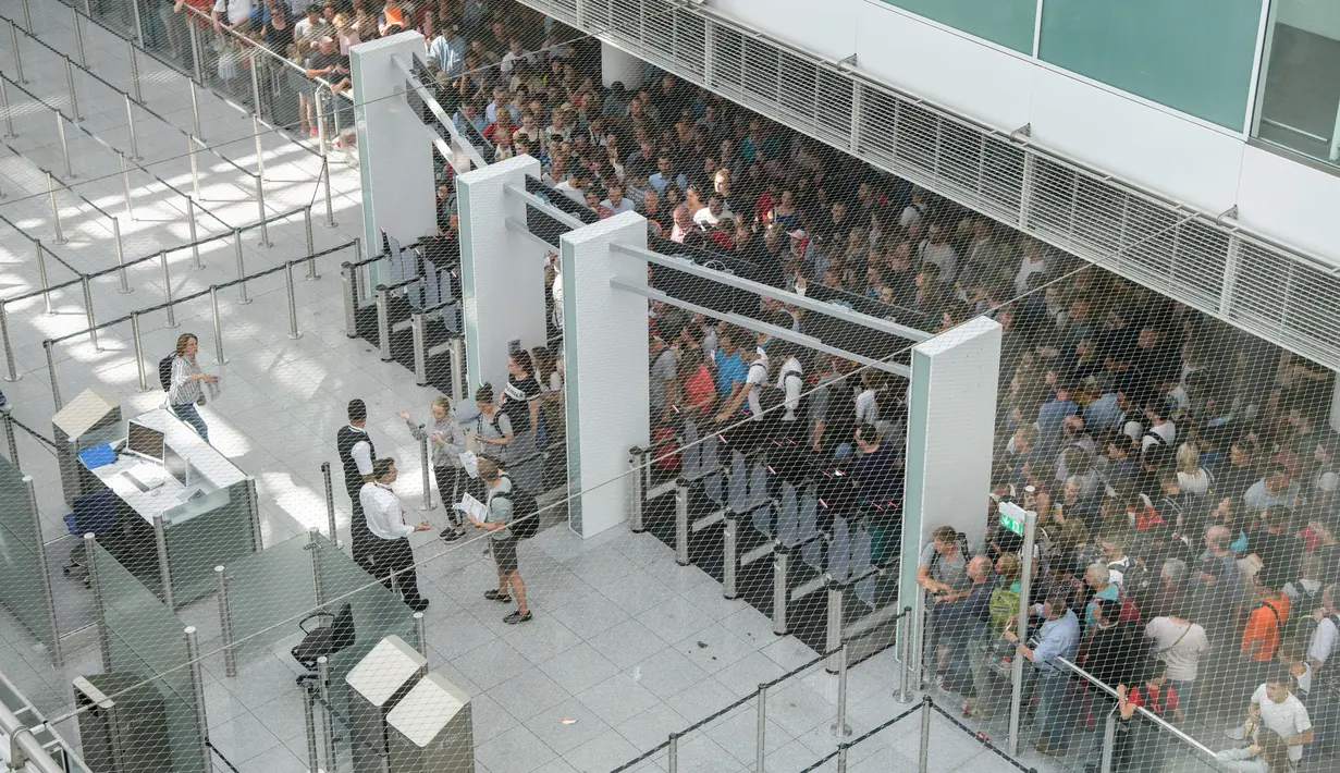Calon penumpang berkumpul di Terminal 2 Bandara Munich, Sabtu (28/7). Kepolisian Jerman menutup terminal 2 bandara tersebut setelah seorang wanita dilaporkan melewati pos keamanan tanpa menjalani pemeriksaan. (MATTHIAS BALK /DPA/AFP)