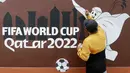 Warga menyelesaikan pembuatan mural bertema Piala Dunia 2022 di Perum Depok Maharaja Blok M1 Cluster Cemara, Rangkapan Jaya, Depok, Jawa Barat, Minggu (30/10/2022). (Bola.com/M Iqbal Ichsan)