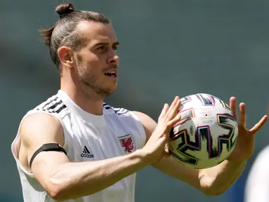 Kapten timnas Wales, Gareth Bale memegang bola selama sesi latihan tim di Stadion Olimpiade Baku di Baku, Azerbaijan, Jumat (11/6/2021). Pertandingan kedua Grup A Euro 2020 akan mempertemukan antara Wales vs Swiss pada Sabtu malam (12/6). (AP Photo/Darko Vojinovic)