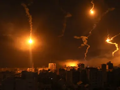 Suar pasukan Israel menerangi langit malam di Kota Gaza, Senin (6/11/2023). Pasukan Israel terus melakukan serangan terhadap Gaza untuk mengincar militan Hamas. (AP Photo/Abed Khaled)