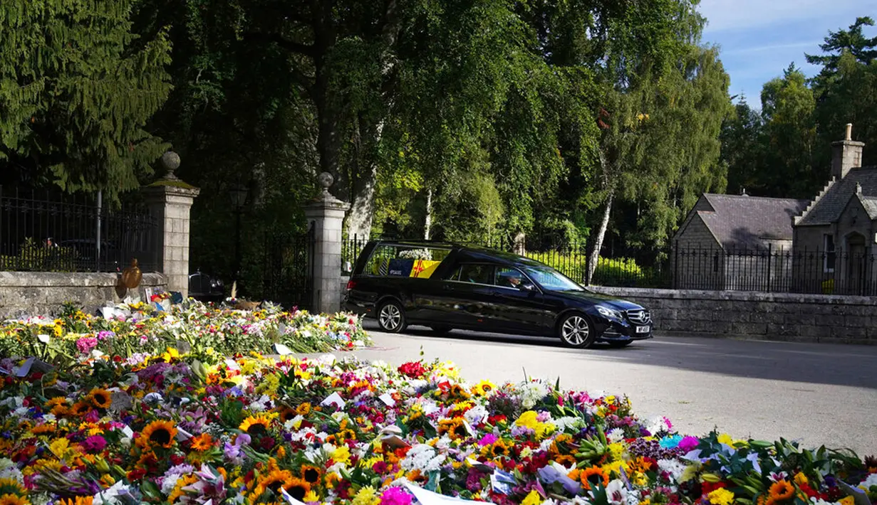Mobil yang membawa peti berisi jenazah Ratu Elizabeth II meninggalkan Kastil Balmoral di Skotlandia, Minggu (11/9/2022). Jenazah Ratu Elizabeth II diberangkatkan dari Kastil Balmoral ke Istana Holyroodhouse di Edinburgh sebelum nantinya akan dipindahkan ke London. (Owen Humphreys/PA via AP)