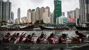 Peserta memacu perahu naga dalam peringatan tahunan Tuen Ng atau Festival Perahu Naga di Hong Kong, Kamis (9/6). Festival tersebut digelar tiap bulan kelima penanggalan Tiongkok. (Anthony WALLACE/AFP)