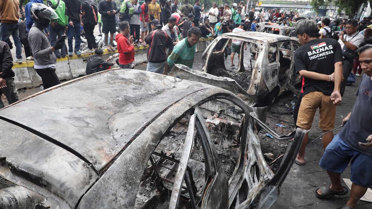 FOTO: Warga Ambil Bangkai Mobil Usai 10 Kendaraan Dibakar di Depan Mako Brimob Kwitang