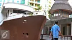Seorang warga berjalan di depan bangunan perahu di Masjid Agung Al Munada Darussalam Baiturrahman, Jakarta, Rabu (24/6/2015). Terdapat bangunan perahu di depan masjid unik tersebut . (Liputan6.com/Helmi Afandi)