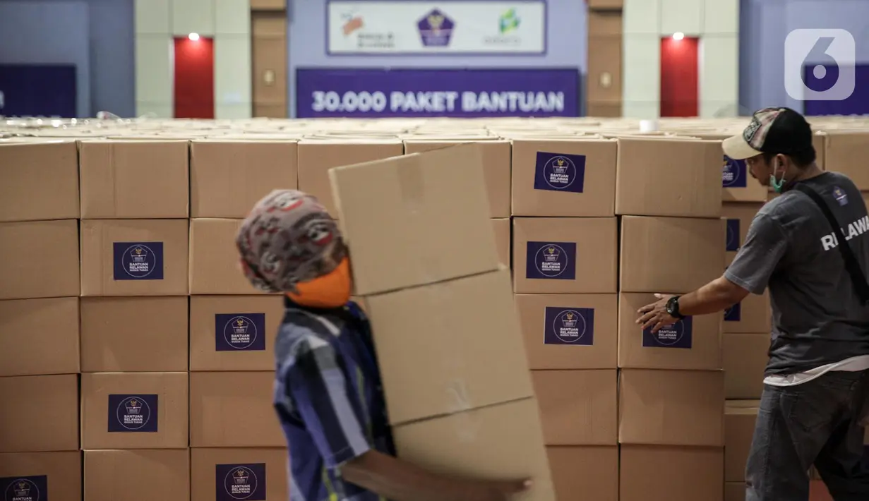 Relawan Gugus Tugas Percepatan Penanganan COVID-19 memindahkan kotak berisi sembako di GOR Gelanggang Remaja, Jakarta, Senin (18/5/2020). Relawan Gugus Tugas Percepatan Penanganan COVID-19 membagikan 30.000 paket bantuan kepada warga Jabodetabek yang terdampak COVID-19. (Liputan6.om/Faizal Fanani)