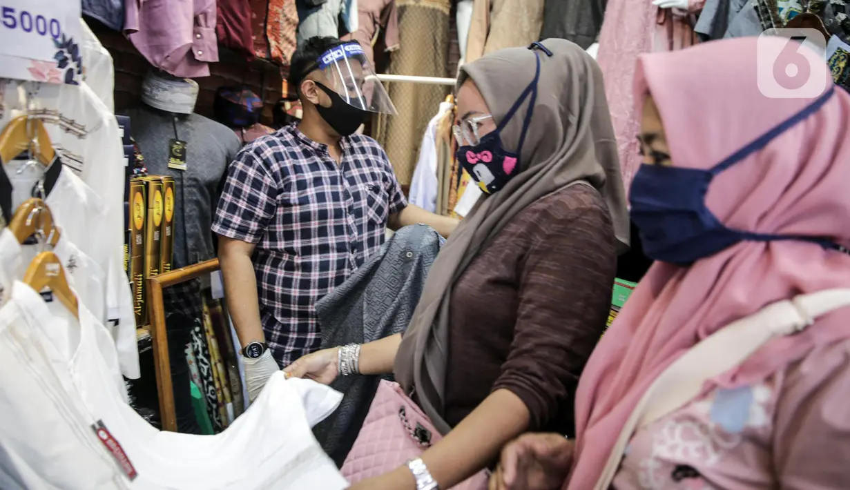 Pedagang menggunakan alat pelindung wajah (Face Shield) saat berjualan di Kawasan Tanah Abang, Jakarta, Senin (18/5/2020). Penggunaan alat pelindung wajah itu sebagai upaya untuk melindungi diri saat berhubungan dengan pembeli dalam pecegahan penyebaran COVID-19. (Liputan6.com/Faizal Fanani)
