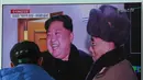 Warga menyaksikan siaran TV yang menampilkan Pemimpin Korea Utara Kim Jong Un tertawa saat berhasil meluncurkan rudal balistik antar benua di Seoul, Korea Selatan (29/11). (AP Photo / Ahn Young-joon)