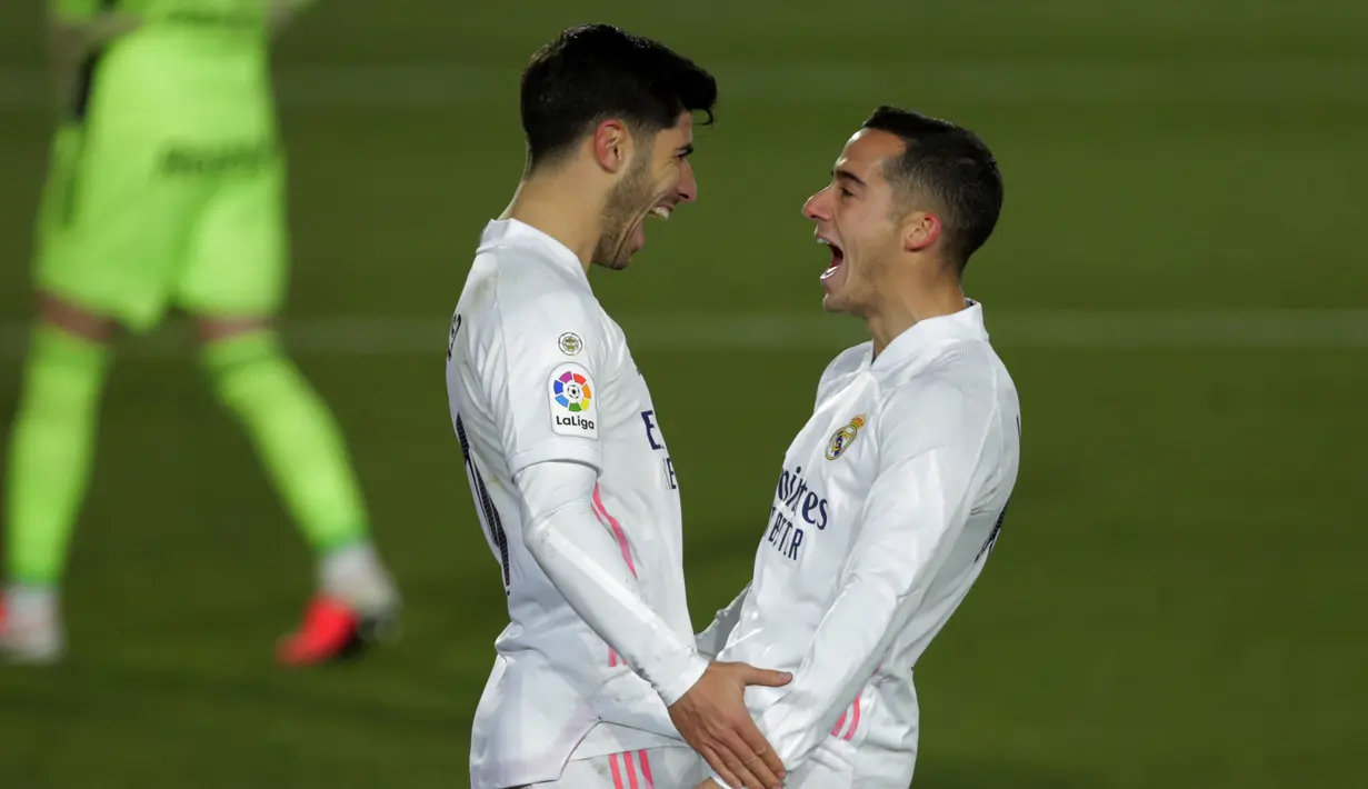 Gelandang Real Madrid, Marco Asensio (kiri) berselebrasi dengan rekannya Lucas Vazquez usai mencetak gol ke gawang Celta Vigo pada pertandingan lanjutan La Liga Spanyol di stadion Alfredo Di Stefano, Minggu (3/1/2021). Madrid menang atas Celta Vigo 2-0. (AP Photo/Manu Fernandez)