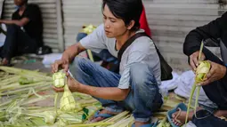 Pedagang menata kulit ketupat dagangannya di sebuah pasar kawasan Ciracas, Jakarta, Kamis (16/7/2015). Menjelang Lebaran, warga mulai ramai membeli kulit ketupat. (Liputan6.com/Faizal Fanani)