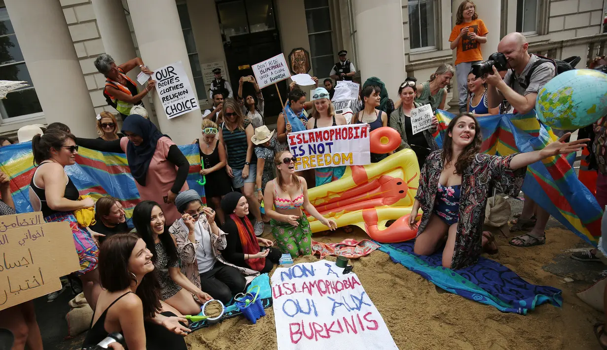 Aksi protes sejumlah wanita dengan mengadakan pesta pantai di luar kedutaan Prancis di London, Inggris, Kamis (25/8). Mereka memprotes larangan burkini (pakaian renang muslimah) yang diberlakukan di beberapa kota pesisir di Prancis. (REUTERS/Neil Hall)