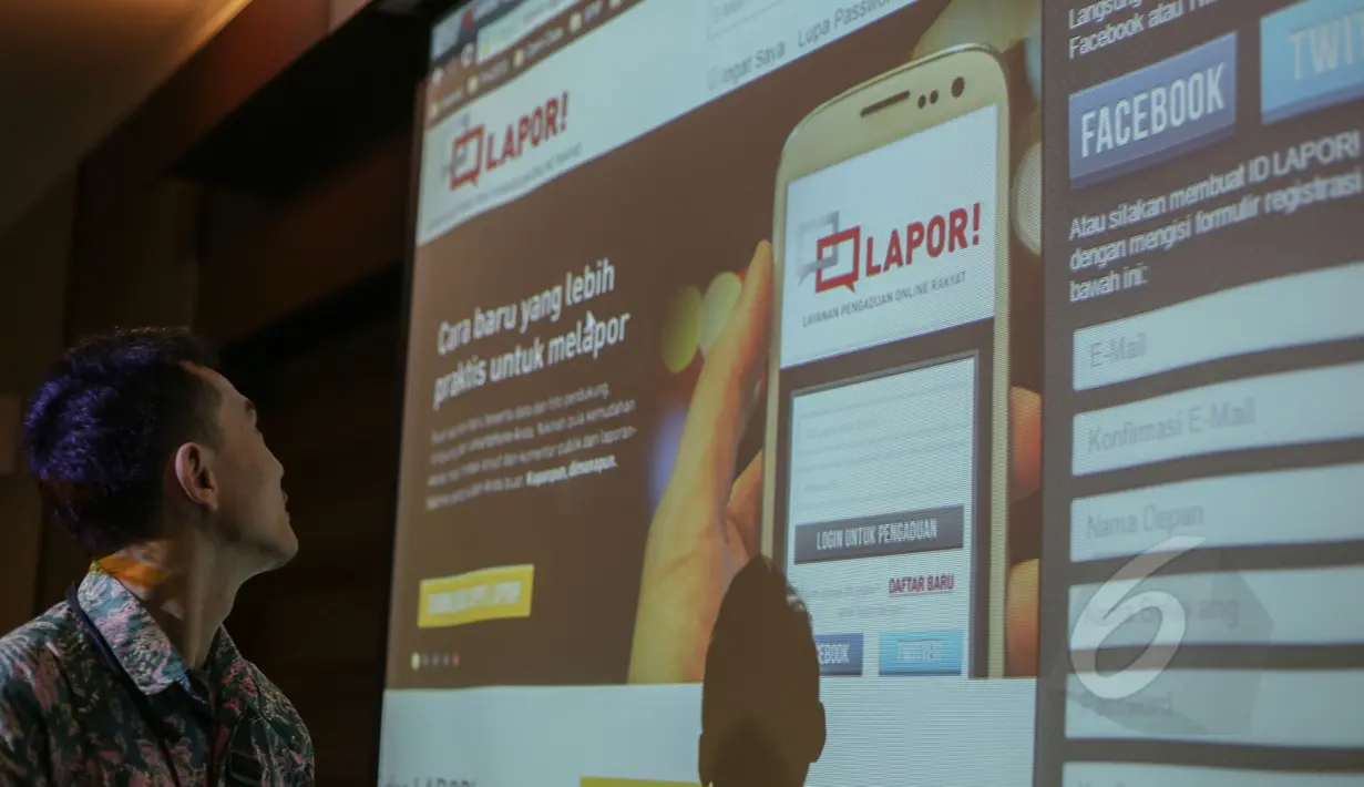 Seorang pria sedang melihat layar yang terdapat situs www.lapor.go.id saat peluncurannya di kantor Staf Kepresidenan, Jakarta, Selasa (5/5/2015). Aplikasi ini dapat diakses melalui www.lapor.go.id. (Liputan6.com/Faizal Fanani) 